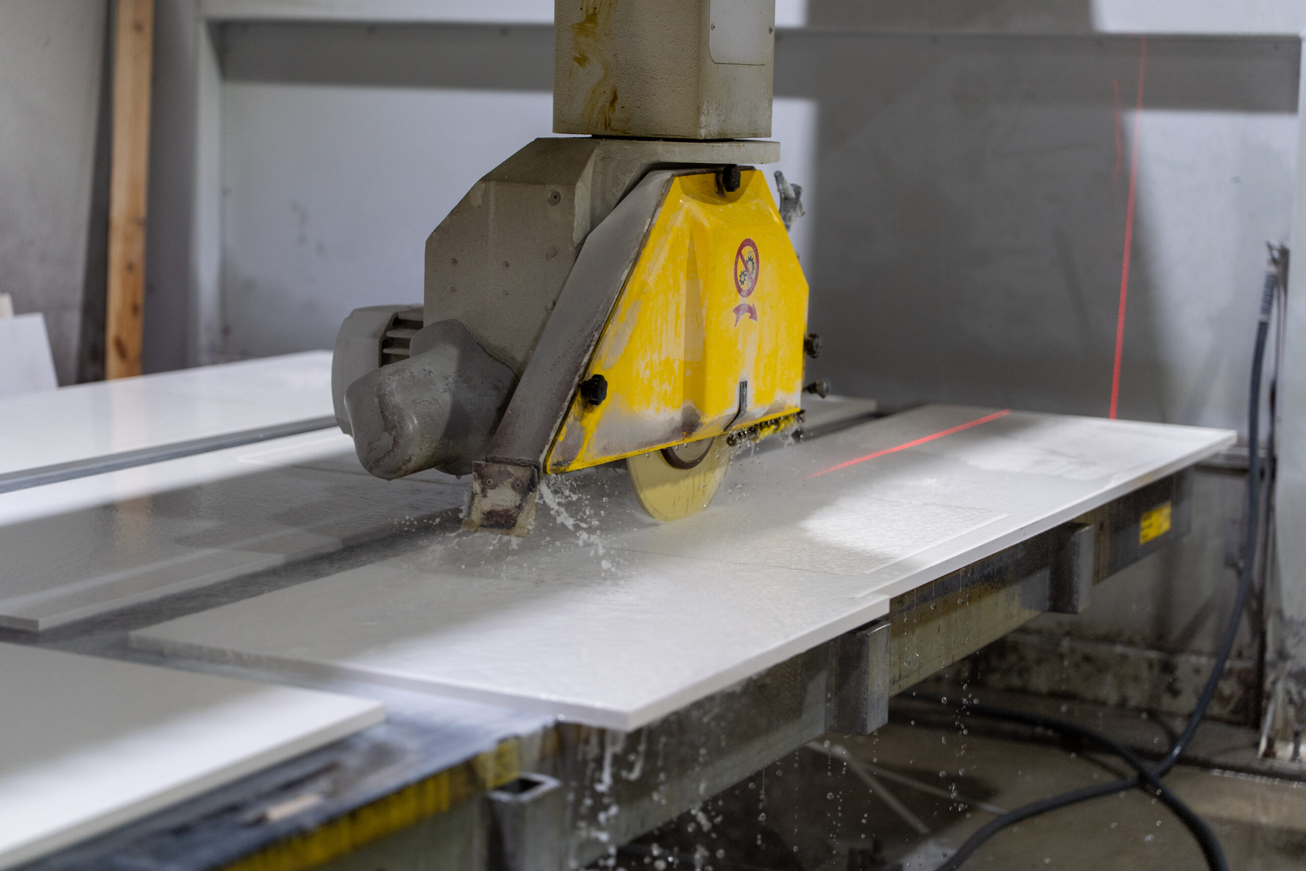 Granite stone slab being cut by a stone cutting machine for countertop fabrication in Bronx, New York.