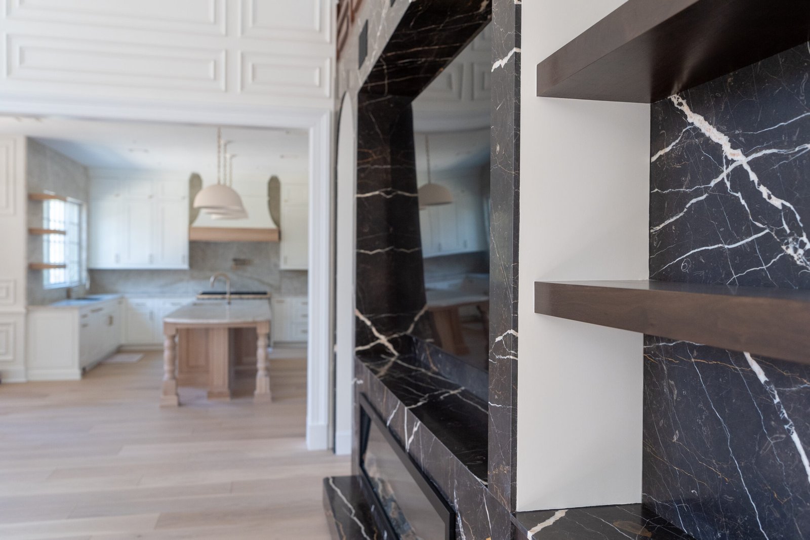 Black marble fireplace feature wall open plan kitchen view