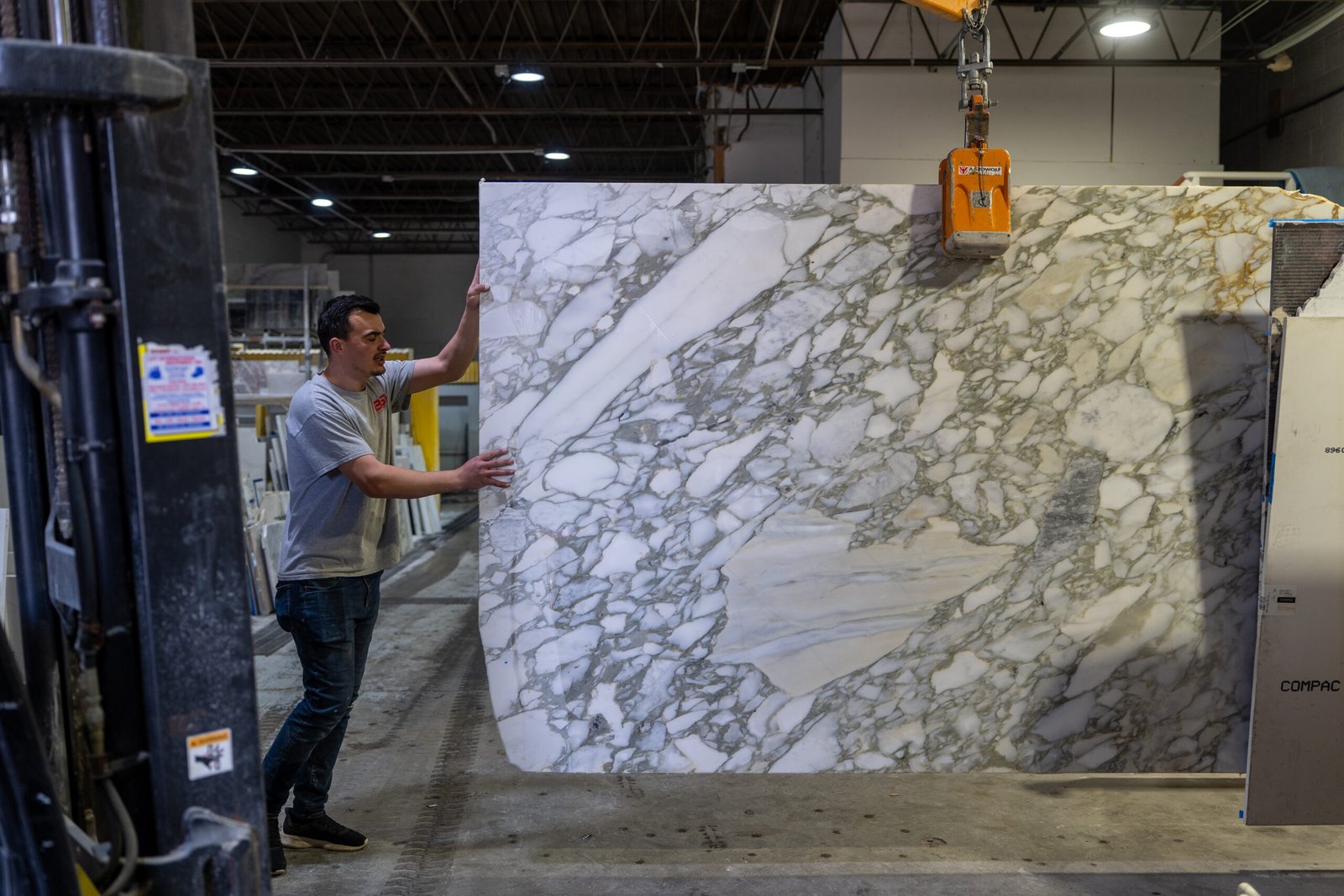 Calacatta Viola marble slab being handled with a vacuum lift
