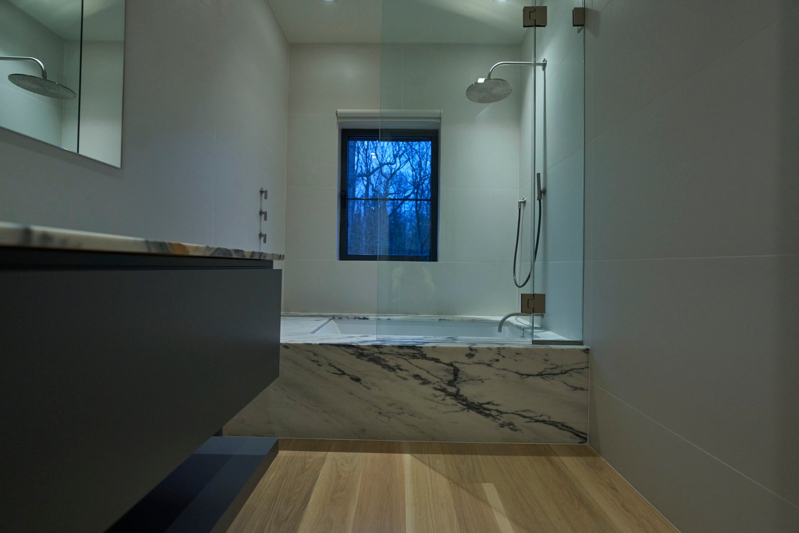 Natural stone shower bench dramatic black veining white bathroom