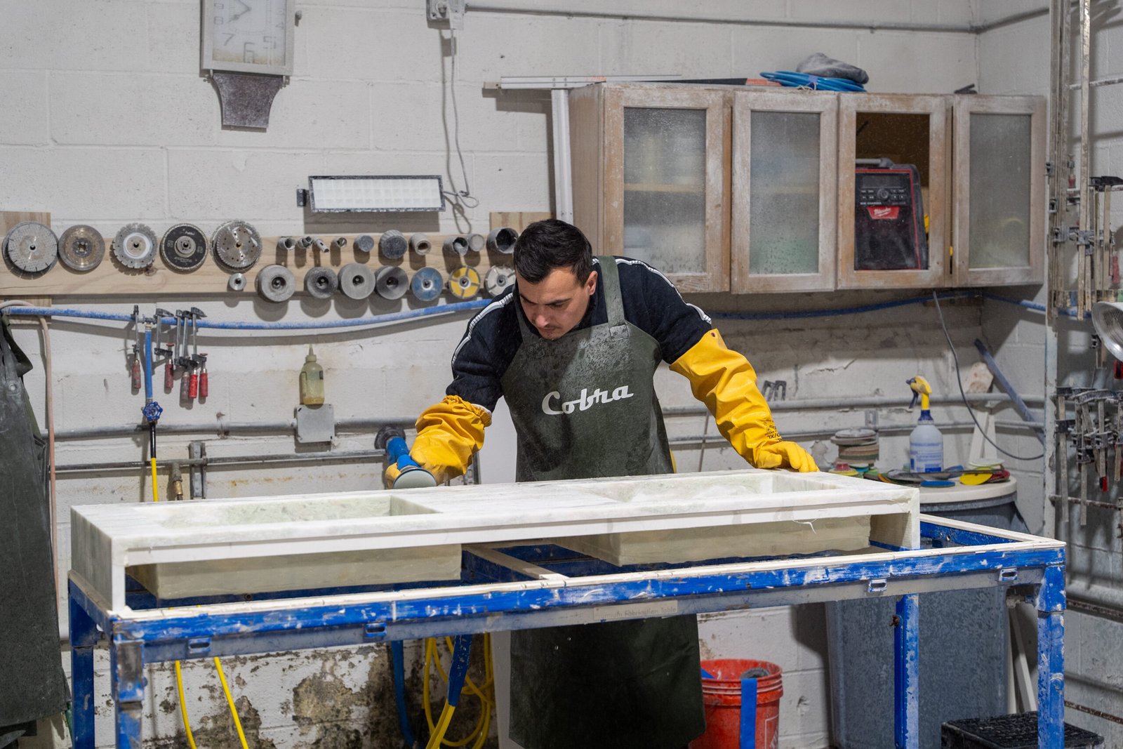 Technician polishing a stone countertop in the fabrication workshop