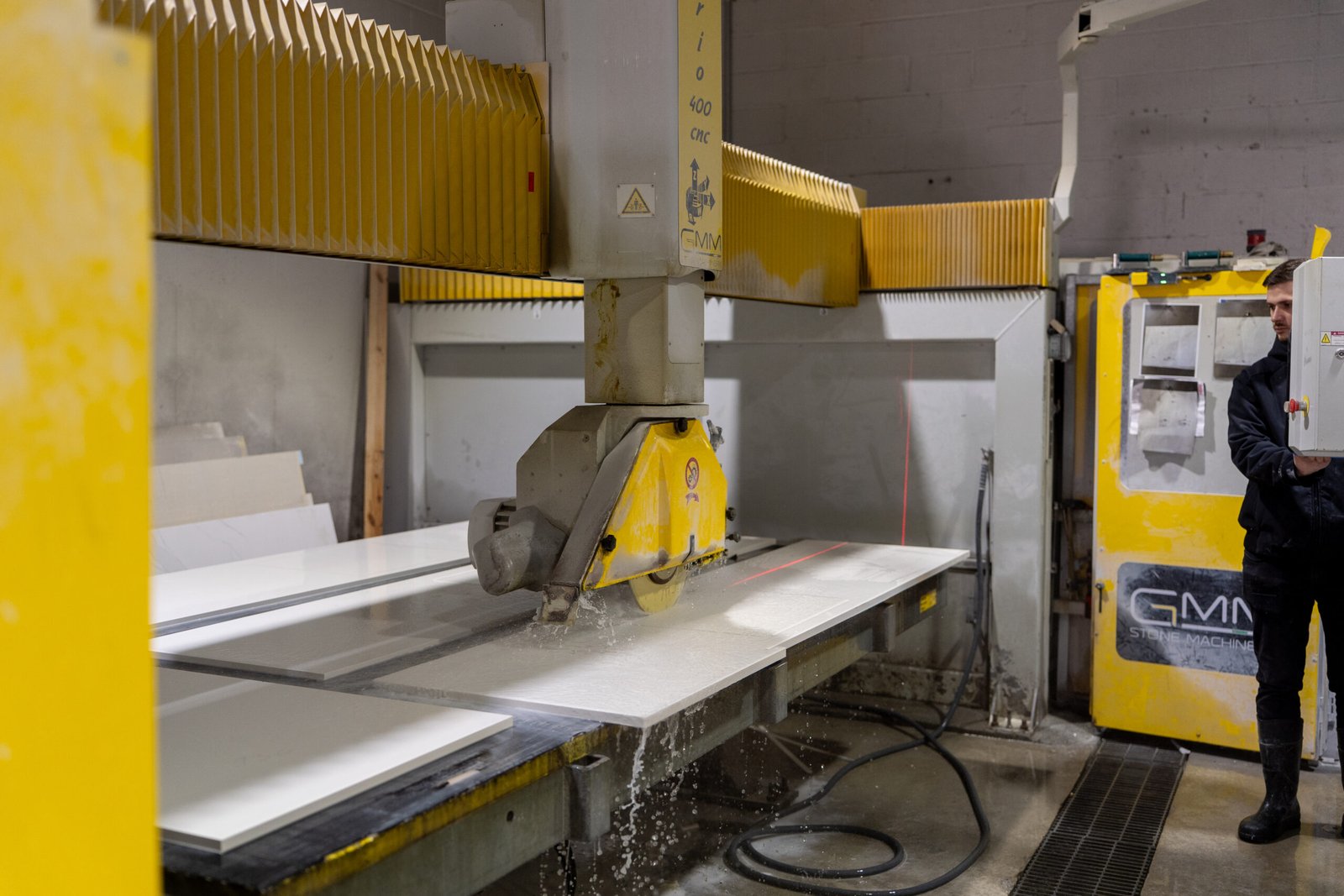 CNC bridge saw cutting a stone slab in the workshop